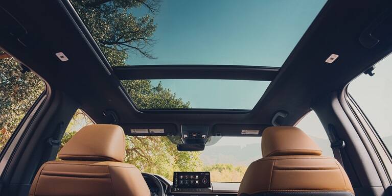 2027 Honda Passport TrailSport Elite interior view of the panoramic sunroof and tan leather seats (Mid-Size SUV).