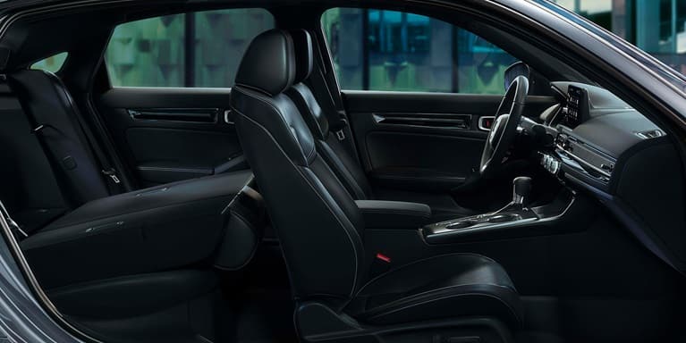 2027 Honda Civic Hatchback Touring Hybrid leather-trimmed seats with rear seat folded down (Compact Hatchback).